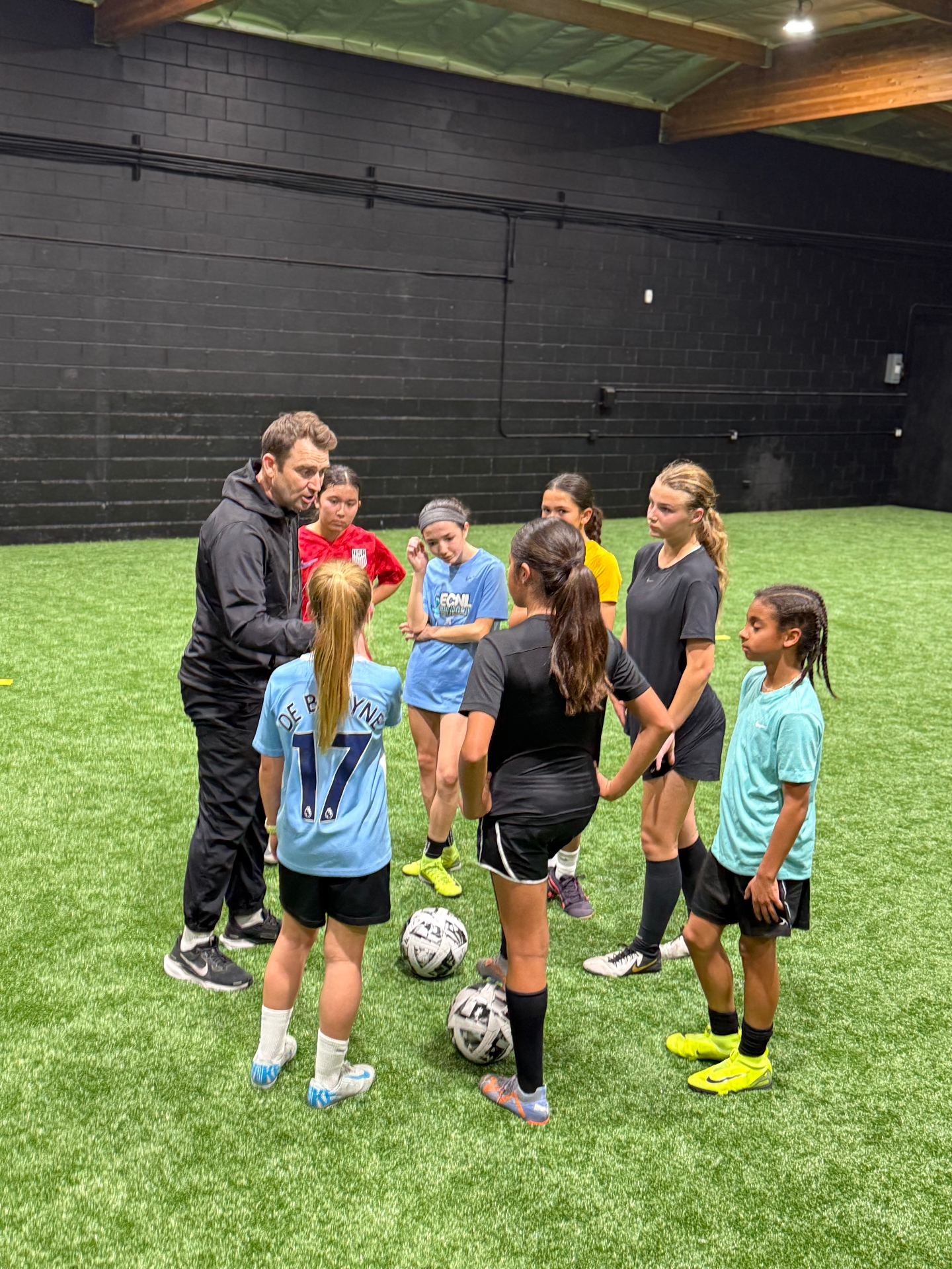 Coach giving a chalk talk to a girls team between drills